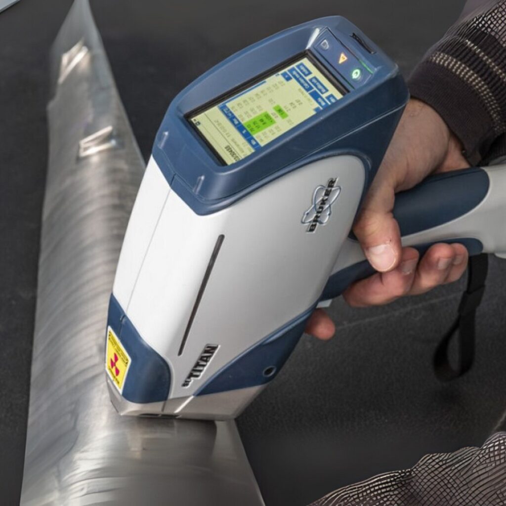 Handheld XRF analyzer reading a steel pipe