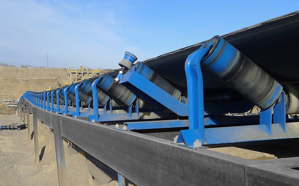 Conveyor idler rollers carrying a belt at an aggregate plant
