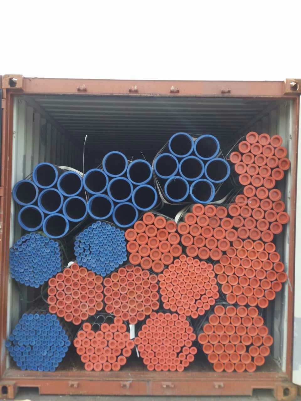 Steel pipes with protective end caps loaded in a shipping container