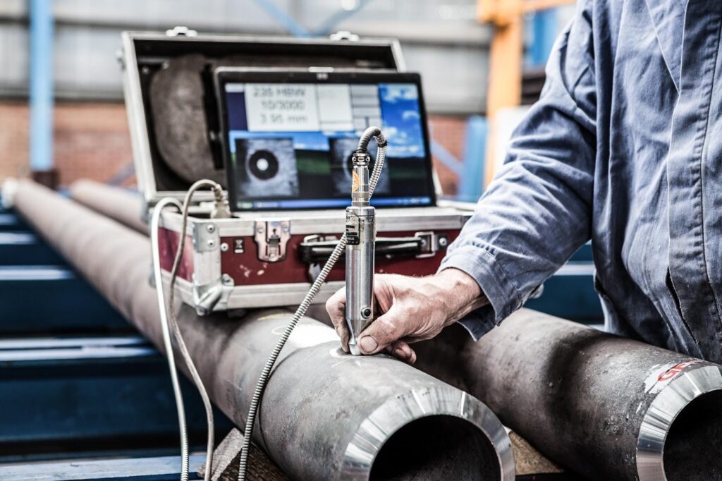 Inspector performing ultrasonic wall thickness measurement